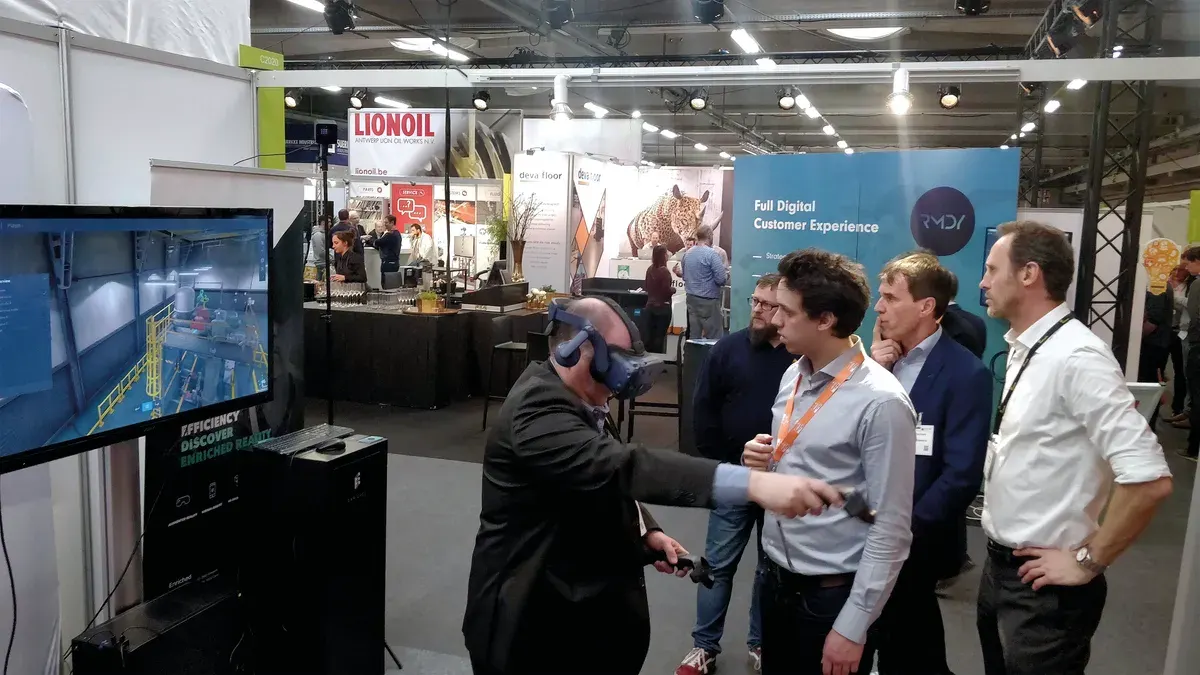 Visitors discussing an Abilitee virtual training demonstration at an exhibition.