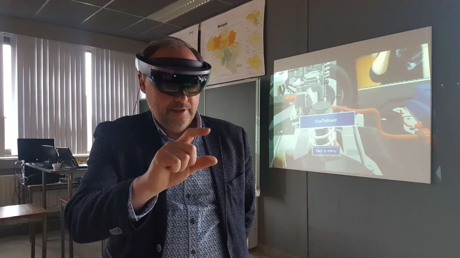 A person wearing a HoloLens headset and interacting with the Diagnose Car application, with the interface projected behind them.